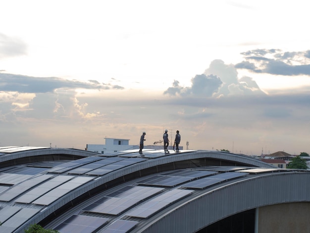 A group of engineers inspecting solar panels on a rooftop in Bogotá, Colombia, with the cityscape in the background. Highlight the modern technology and the sustainable urban development.