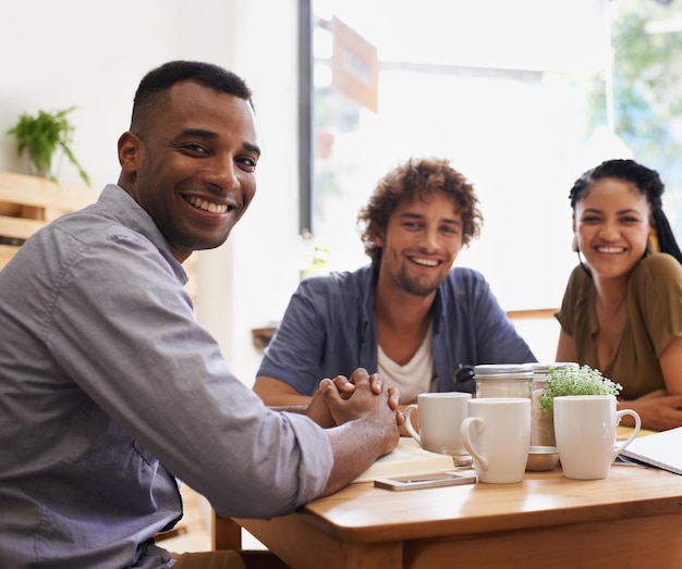 A group of entrepreneurs from colombia meeting across a table smiling.
