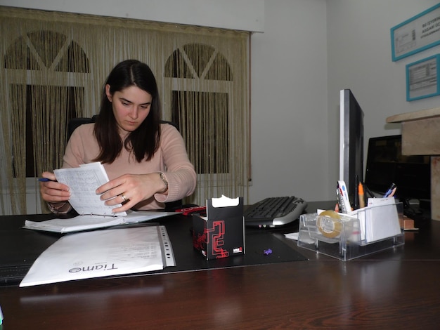 A Colombian citizen in a modern office, reviewing documents related to a mortgage application. The scene should convey professionalism, attention to detail, and the importance of having complete and accurate paperwork.