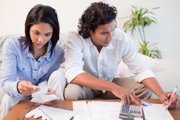 A Colombian family sitting at a table, reviewing financial documents and discussing their mortgage options. The scene should convey collaboration, careful planning, and the importance of making informed decisions together.