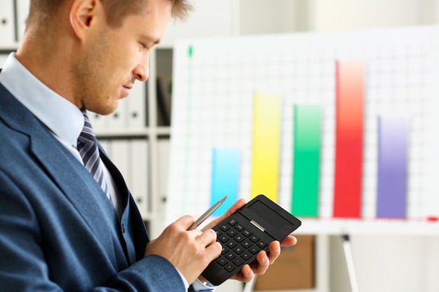 A person reviewing financial documents and using a calculator, representing the process of comparing different retirement savings plans and their potential returns. The image should convey careful financial planning.