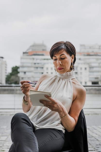 A young Colombian woman using her smartphone to manage her investment portfolio on a mobile app, showcasing digital finance and investment management.
