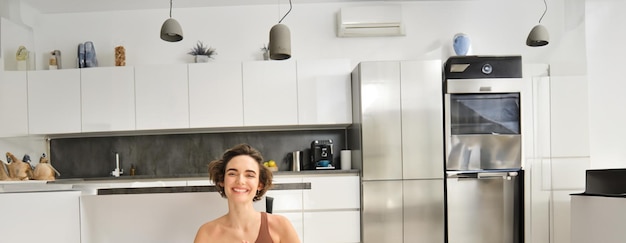 A modern kitchen with energy-efficient appliances, including a refrigerator with an energy star rating and a dishwasher being loaded with dishes. Sunlight streams through the window, highlighting the appliances and the clean, sustainable design of the kitchen.