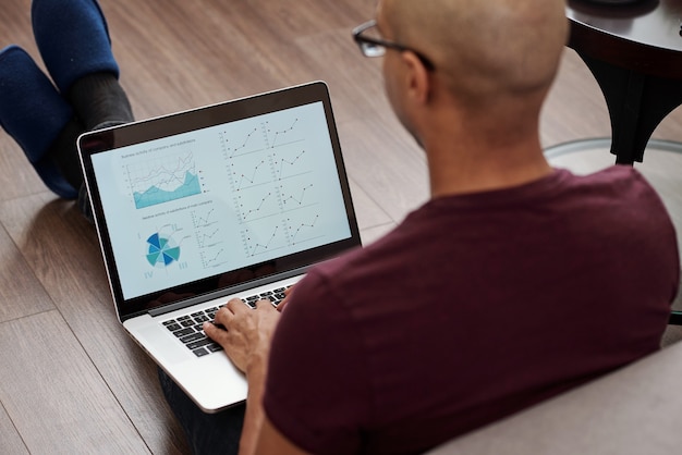 A person using a laptop to compare loan options from different financial institutions, with charts and graphs in the background representing interest rates and loan terms. The scene should convey a sense of informed decision-making.