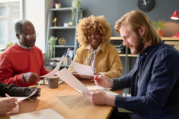 A diverse group of local entrepreneurs collaborating around a table, reviewing documents and discussing strategies for tax incentives. The atmosphere is positive and collaborative.