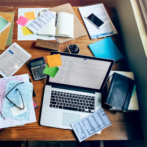 An organized desk with various documents and a laptop displaying a government website related to business permits and licensing in Colombia. Show a sense of order and preparation.