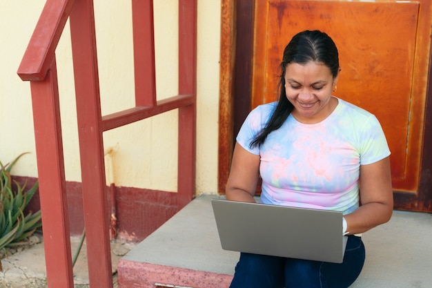 A close-up shot of a small business owner in Colombia using a laptop while surrounded by sustainable products, showcasing the integration of technology and eco-friendly practices in their day-to-day operations.